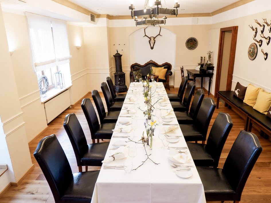 Hochzeitslocation Oberpfalz gesucht? Eleganter Essbereich mit langem Tisch und schwarzen Stühlen, dekoriert mit Blumen