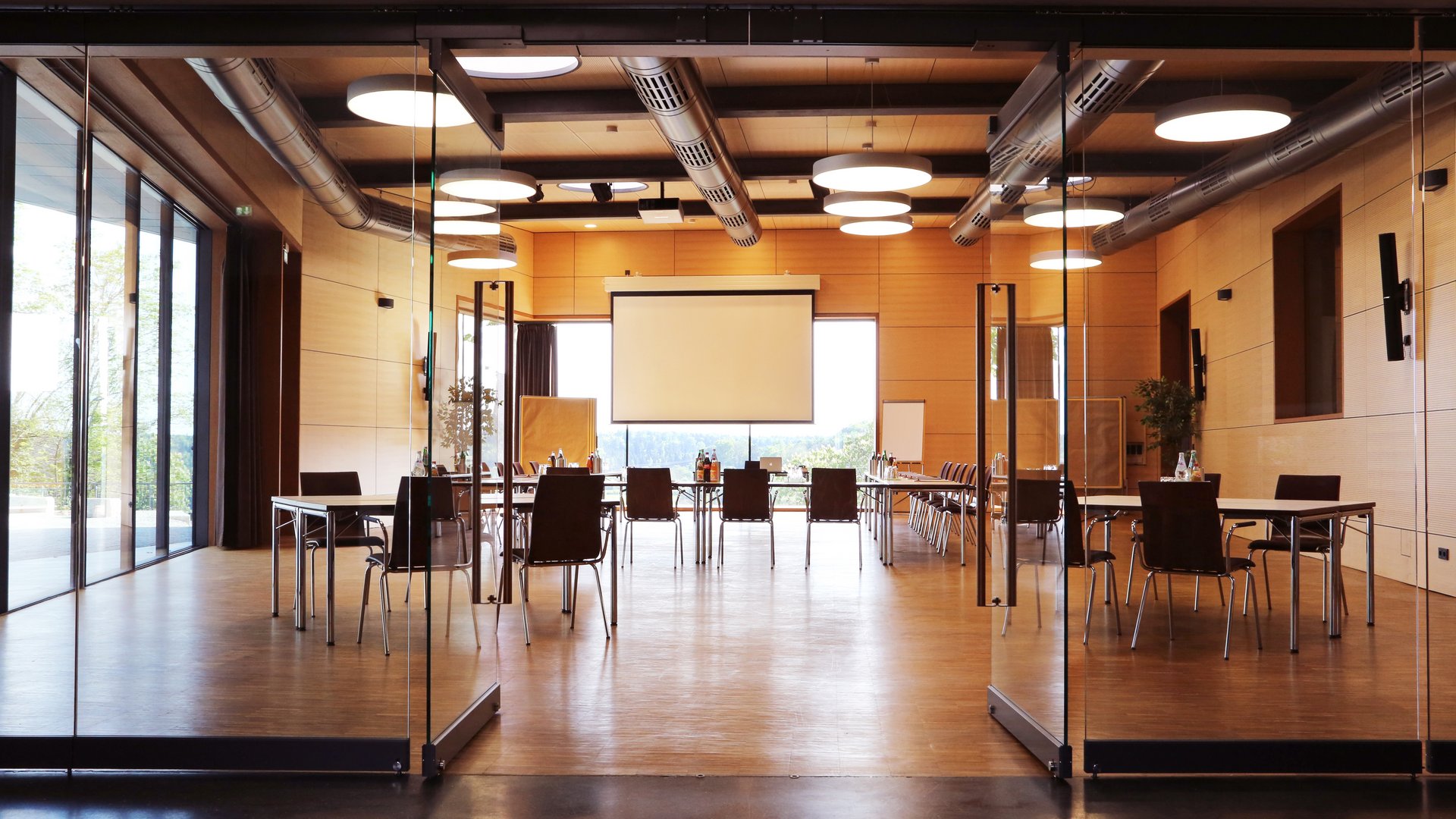 Tagungshotel Oberpfalz: Das Hotel für Deine Tagung Moderner Konferenzraum mit Glaswänden und Projektionsleinwand