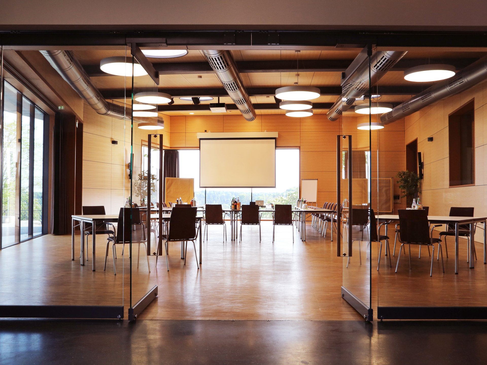 Tagungshotel Oberpfalz: Tagungsräume & Seminarräume im Romantik Hotel Hirschen Moderner Konferenzraum mit Glaswänden und Projektionsleinwand