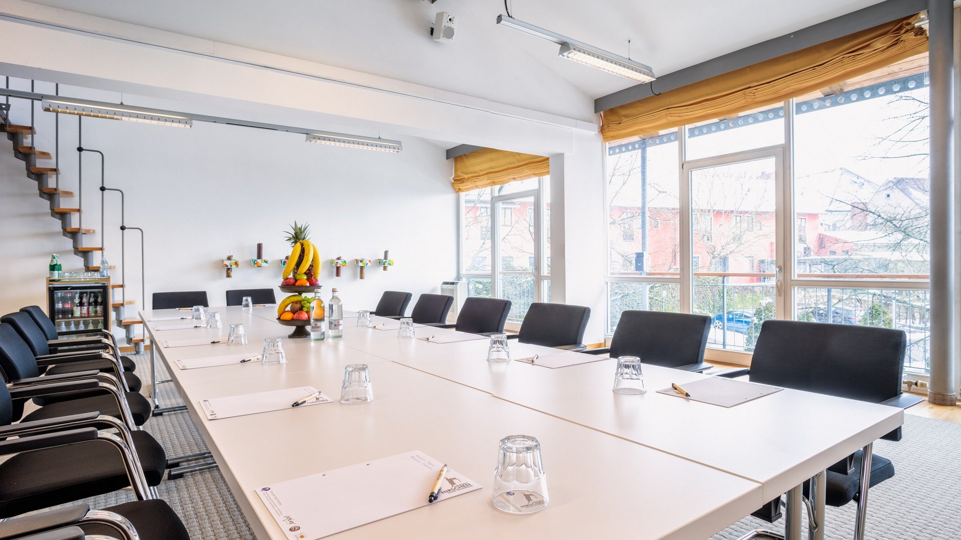 Tagung mit Mehrwert Helles, modern eingerichtetes Besprechungszimmer mit Tischen, Stühlen und Obstkorb