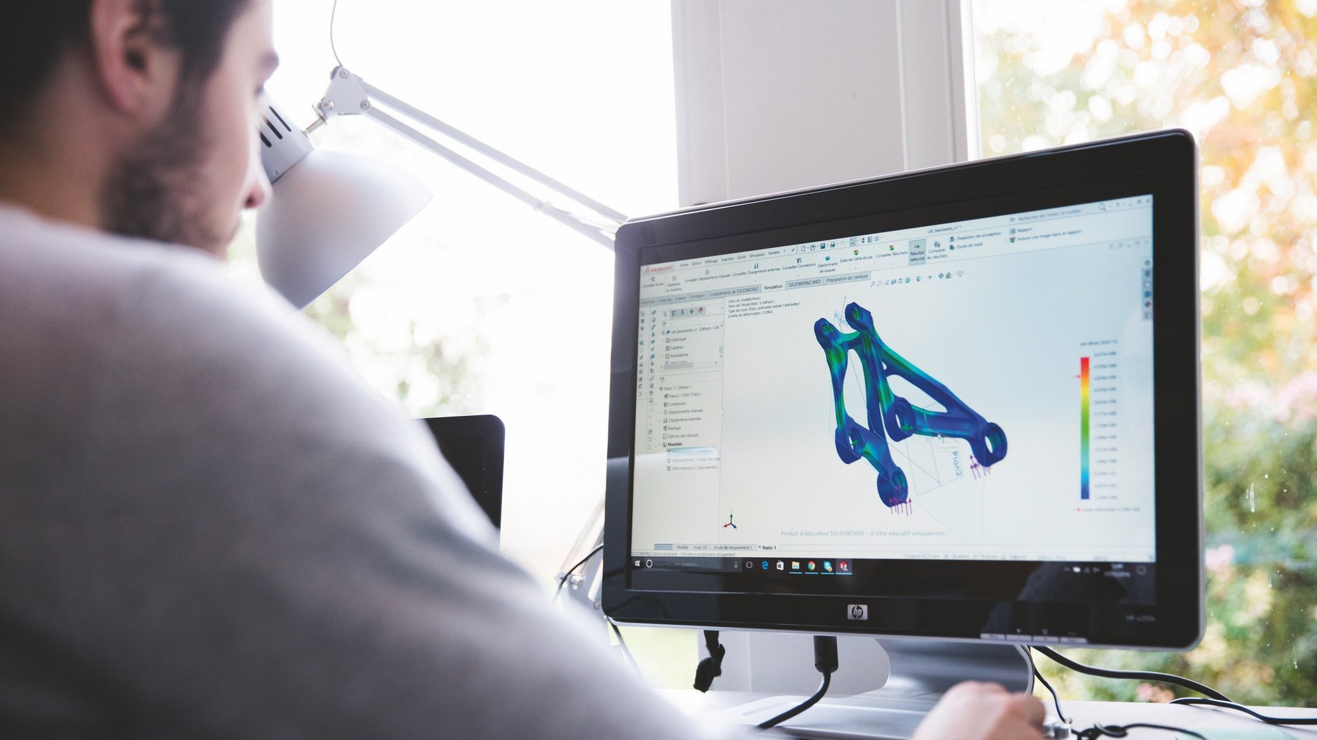 Hotel mit Fahrradverleih in Bayern gesucht? Person arbeitet an 3D-Modellierung und Simulation auf Computer am Schreibtisch
