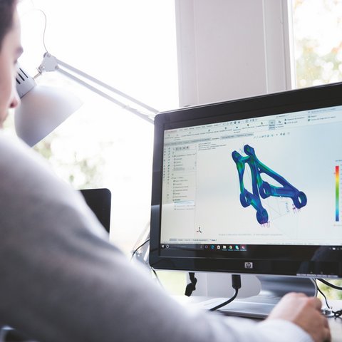 Hotel mit Fahrradverleih in Bayern gesucht? Person arbeitet an 3D-Modellierung und Simulation auf Computer am Schreibtisch