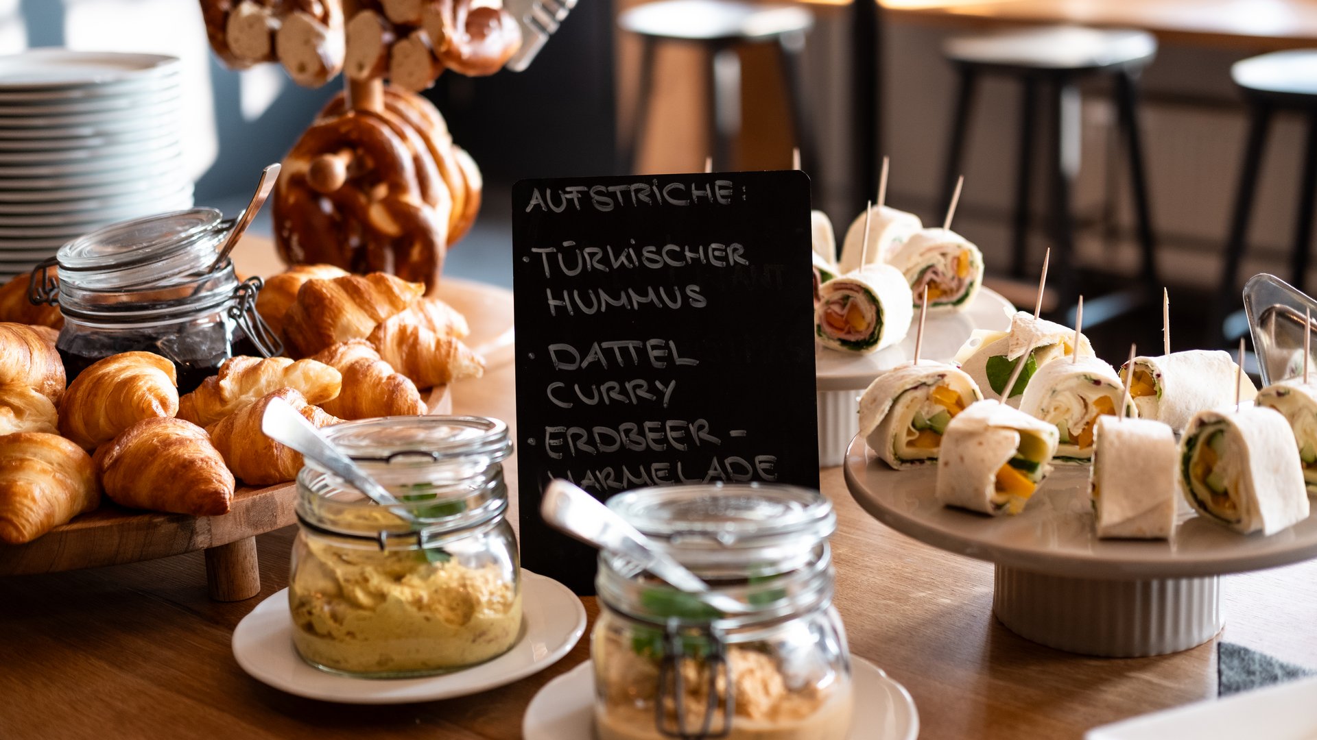 Tagung mit Mehrwert Buffet mit Croissants, Dips, Wraps und Brezeln in einem hellen Raum