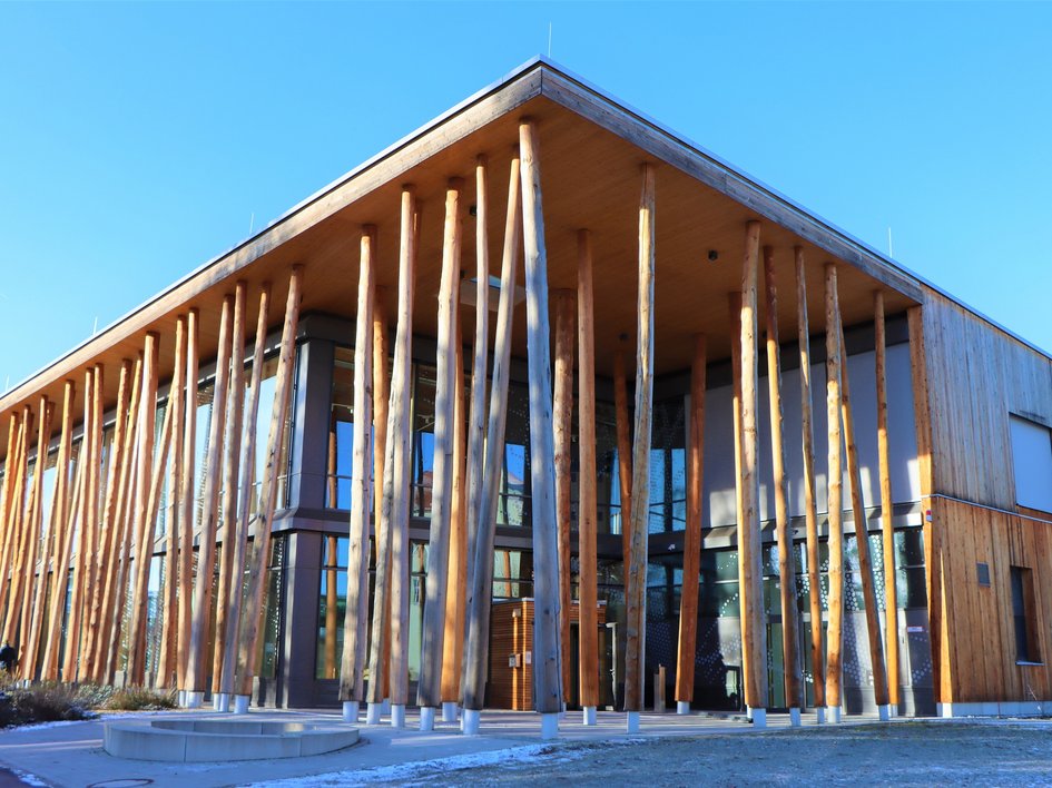 Hotels in Regensburg und Umgebung: kultur-trächtig! Modernes Gebäude mit vertikalen Holzpfosten und Glasfassade bei klarem Himmel