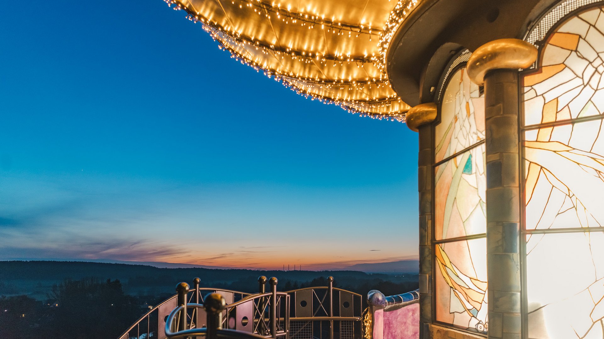 Weihnachtsmärkte Beleuchtete Aussichtsterrasse mit bunten Glasfenstern und Abendhimmel