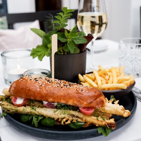 Guesthouse in Parsberg: A salute to great taste Sandwich with fries and white wine on a set table