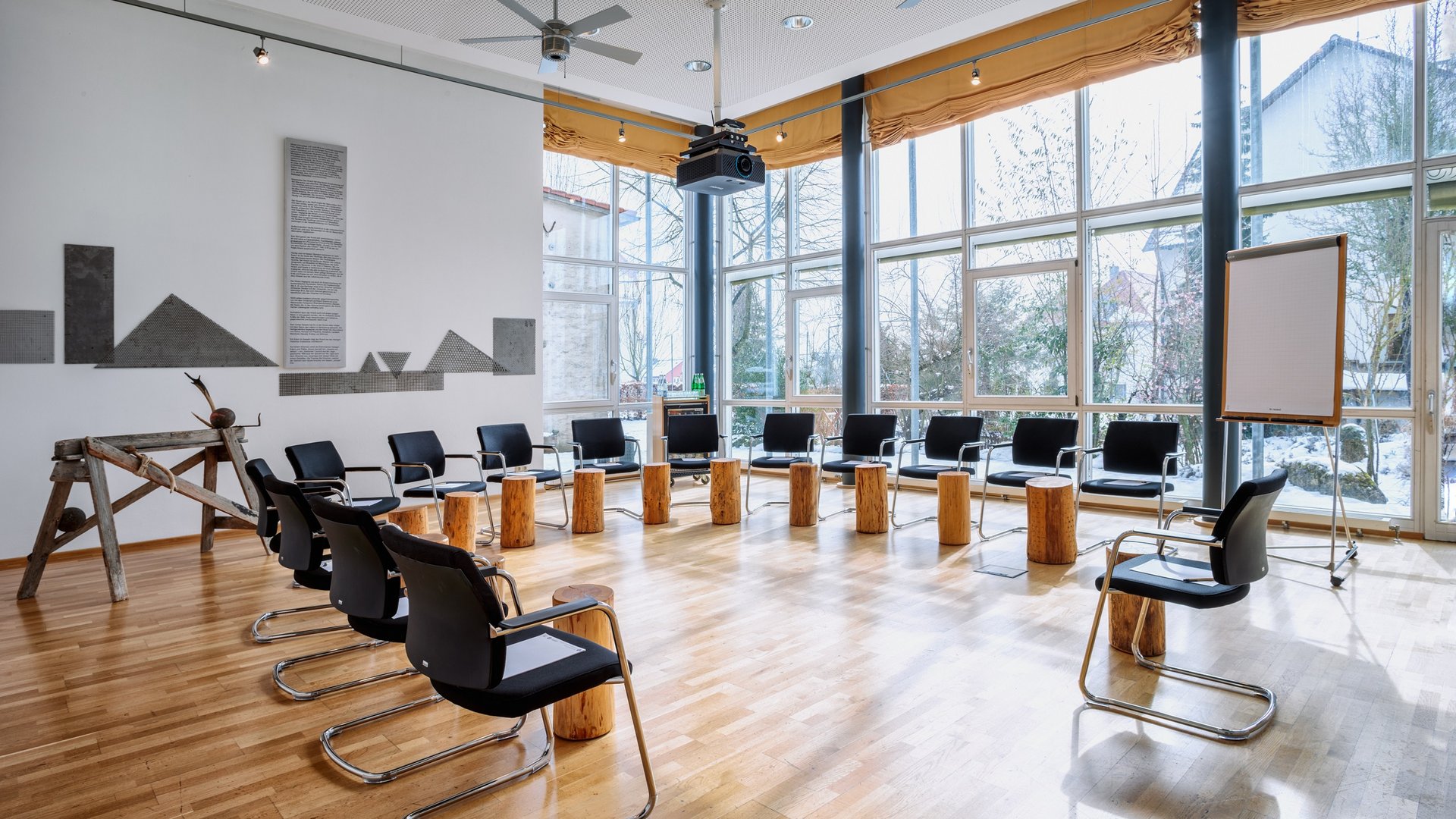 Heller Sitzungssaal mit Stühlen und Holzstümpfen in einem Kreis