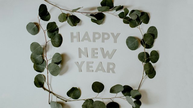Romantik Hotel Hirschen: Blog Blätterkranz um die Schrift Frohes Neues Jahr auf weißem Hintergrund