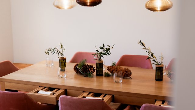 Brunch - das Langschläferfrühstück Moderner Esstisch mit roten Stühlen, verziert mit Tannenzapfen und Pflanzenzweigen