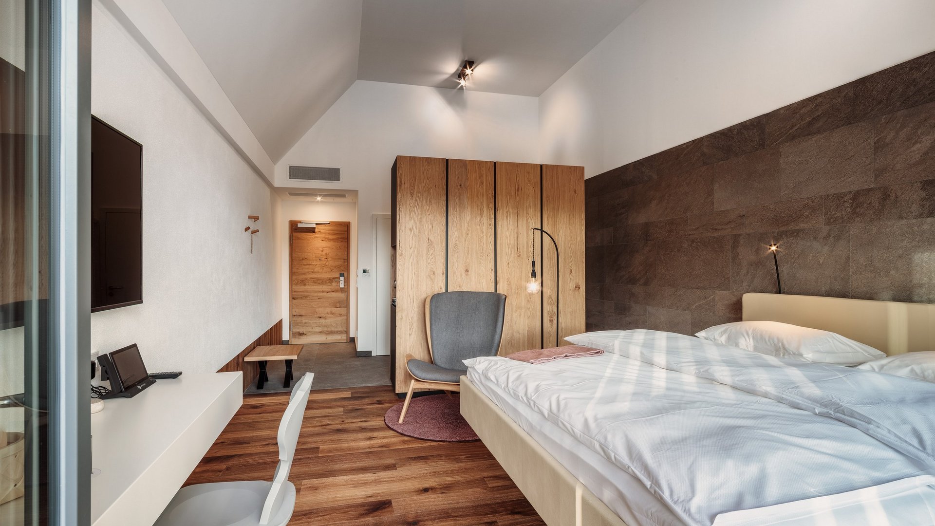 Romantik Hotel Hirschen: Blog Modernes Hotelzimmer mit Doppelbett, Schrank und Schreibtisch