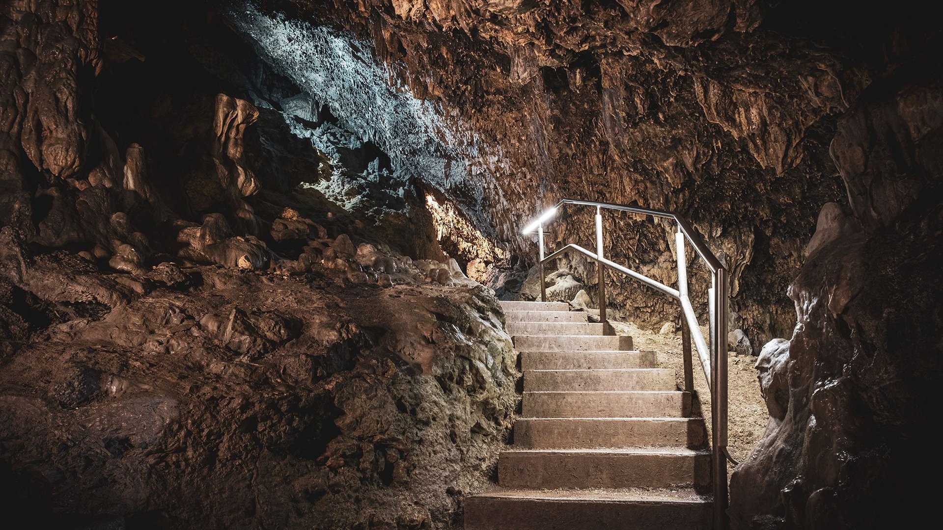 Hiking in Upper Palatinate: Active in nature Lit staircase inside a natural rocky cave with handrail