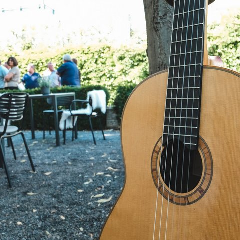Kulinarik & Genuss in der Oberpfalz Akustikgitarre im Garten mit Stühlen und Menschen im Hintergrund
