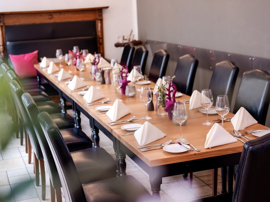 Hochzeitslocation Oberpfalz gesucht? Eleganter gedeckter Esstisch mit schwarzen Stühlen und weißen Servietten