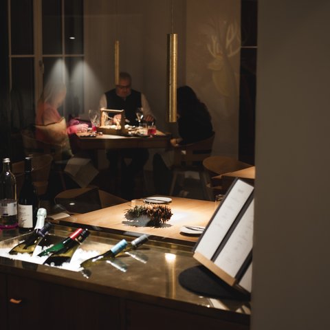 Fine Dining & Gourmet Cuisine in the Upper Palatinate View through door of people dining in cozy restaurant with wine bottles in foreground