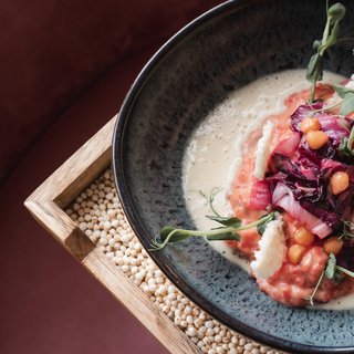 Wellnesshotel in Parsberg mit Spa, Genuss und stilvollen Zimmern. Elegantes Gericht mit Kichererbsen, Rotkohl, Käsestücken und Kräutern auf Teller