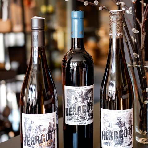 Eco-friendly hotel in Germany with Hirschenmanufaktur Three Herrgott wine bottles with artistic labels and decorative branches