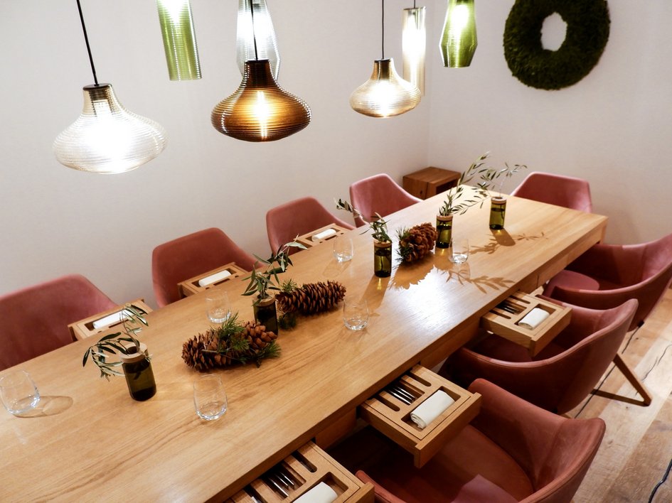 Hochzeitslocation Oberpfalz gesucht? Moderner Esstisch mit rosa Stühlen, Holzschubladen und Pendelleuchten