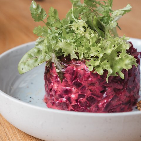 Gasthof Parsberg: Ein Gruß an den guten Geschmack Rote Rote-Bete-Salat mit frischen grünen Blättern auf weißem Teller