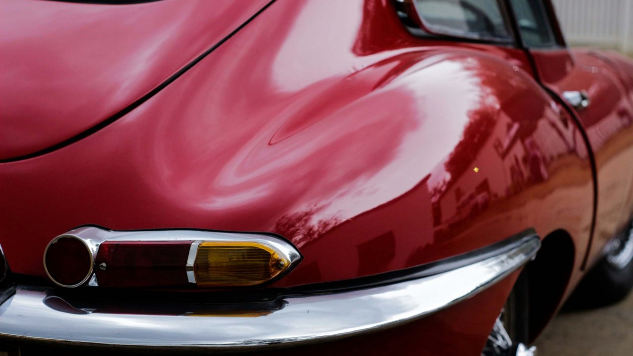 Close-up of red vintage car rear light with chrome bumper
