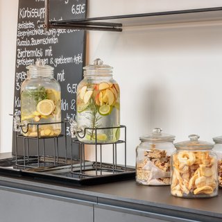 Regensburger Christkindlmarkt Glaskaraffen mit Früchten und drei Gläser mit Snacks auf der Theke