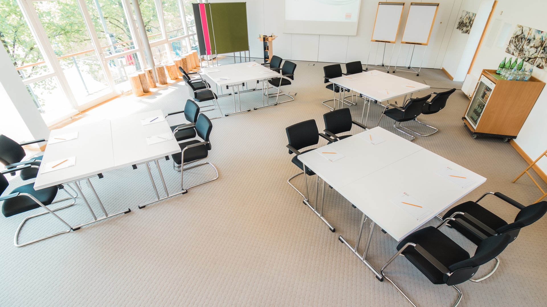 Tagung mit Mehrwert Helles Konferenzzimmer mit Tischen, Stühlen und Whiteboards