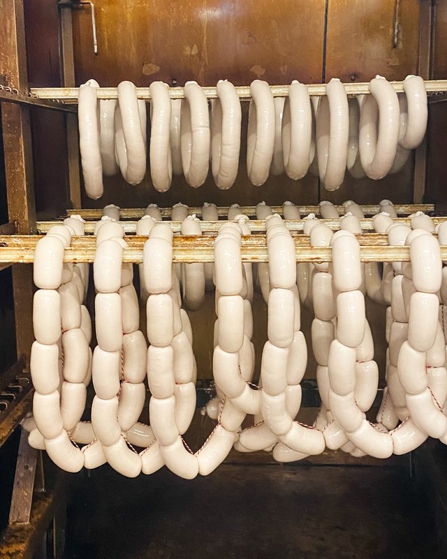 Nachhaltige Hotels in Deutschland gesucht? Weißwürste hängen zum Trocknen in einem Räucherofen