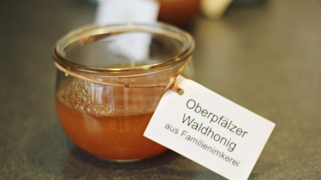 Looking for sustainable hotels in Germany? Jar of Oberpfalz forest honey with label from family beekeeping