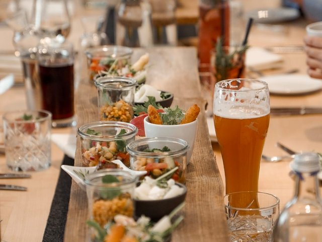 Romantik Hotel Hirschen: Bildergalerie Langer Holztisch mit kleinen Vorspeisen und Getränken in einem Restaurant