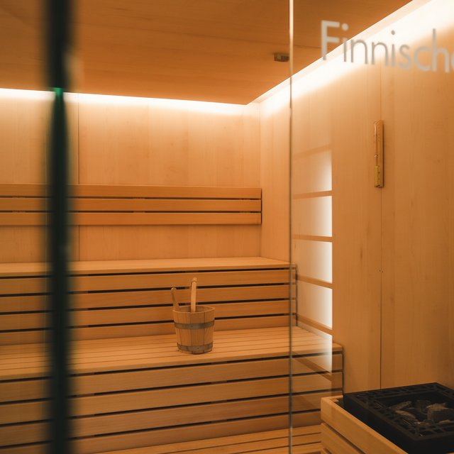 Alles Wichtige für Deinen Aufenthalt im Hirschen Innenansicht einer finnischen Sauna mit Holzbänken und Saunaeimer