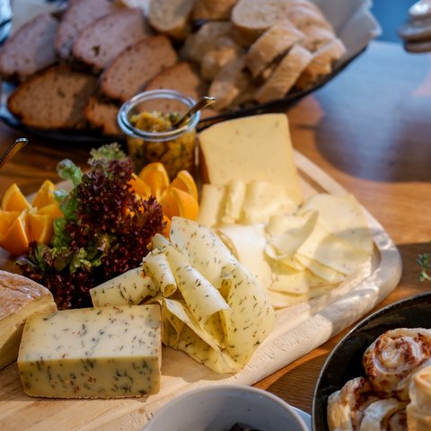 Guesthouse in Parsberg: A salute to great taste Assortment of cheeses, bread, nuts, and snacks on a wooden table