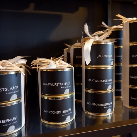 Eco-friendly hotel in Germany with Hirschenmanufaktur Stacked cans of Bavarian sausage and Leberkäse varieties on a shelf