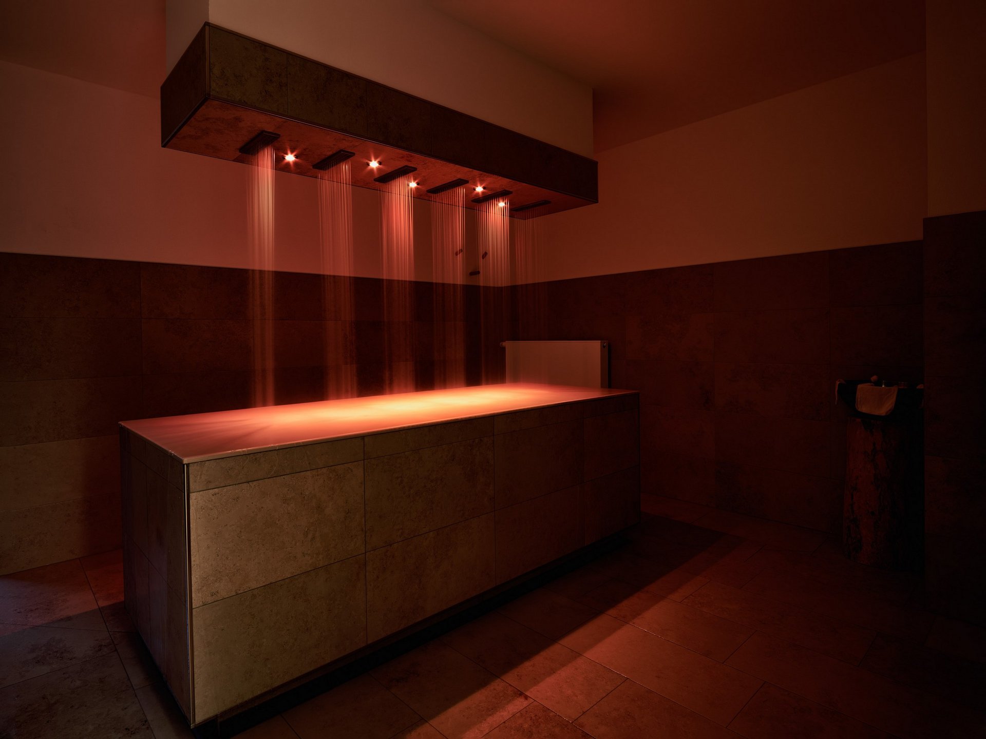 Saunas, Pool & Natural Pool in the Upper Palatinate | Romantik Hotel Hirschen Modern wellness shower with red lighting in a spa room
