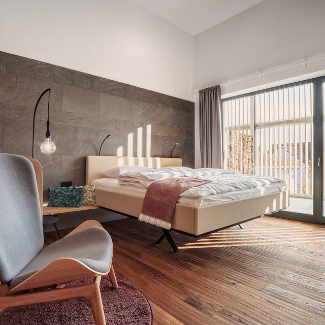 Romantik Hotel in Upper Palatinate: Come back soon! Modern bedroom with large bed and chair near floor-to-ceiling windows