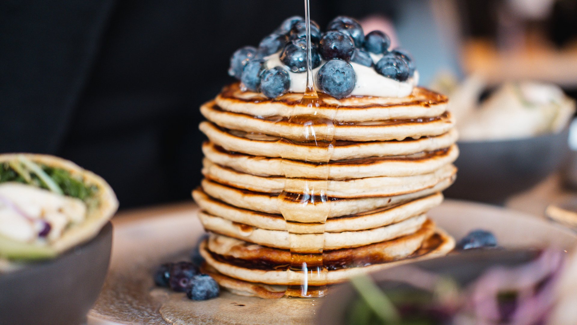 Pfannkuchenstapel mit Blaubeeren und Sirup auf einem Teller serviert