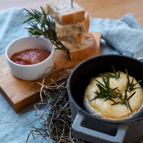 Gasthof Parsberg: Ein Gruß an den guten Geschmack Geschmolzener Käse mit Rosmarin in einem Topf, serviert mit Brot und Sauce