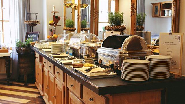 Looking for sustainable hotels in Germany? Buffet with plates, cutlery, and covered dishes in a restaurant