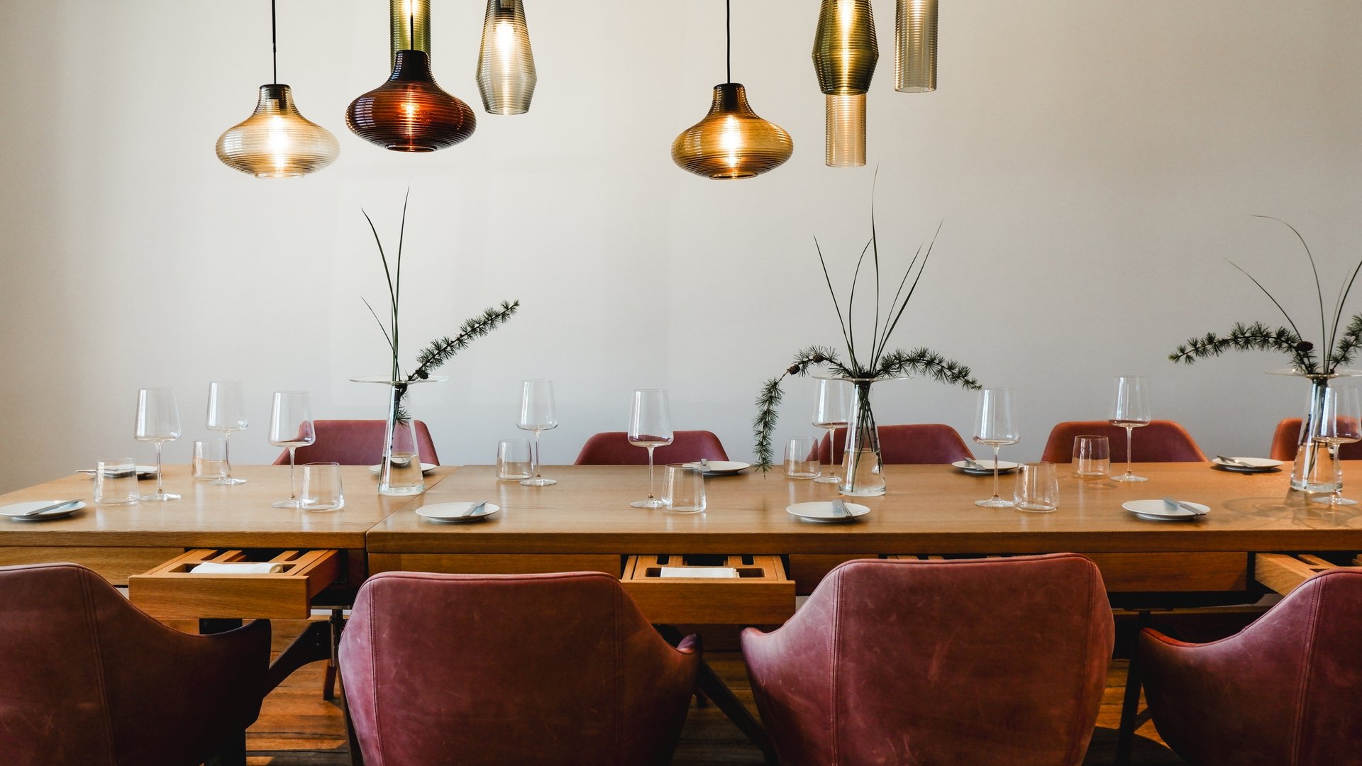 Restaurant in Parsberg: Gourmet genießen Moderner Esstisch mit roten Stühlen und hängenden Lampen