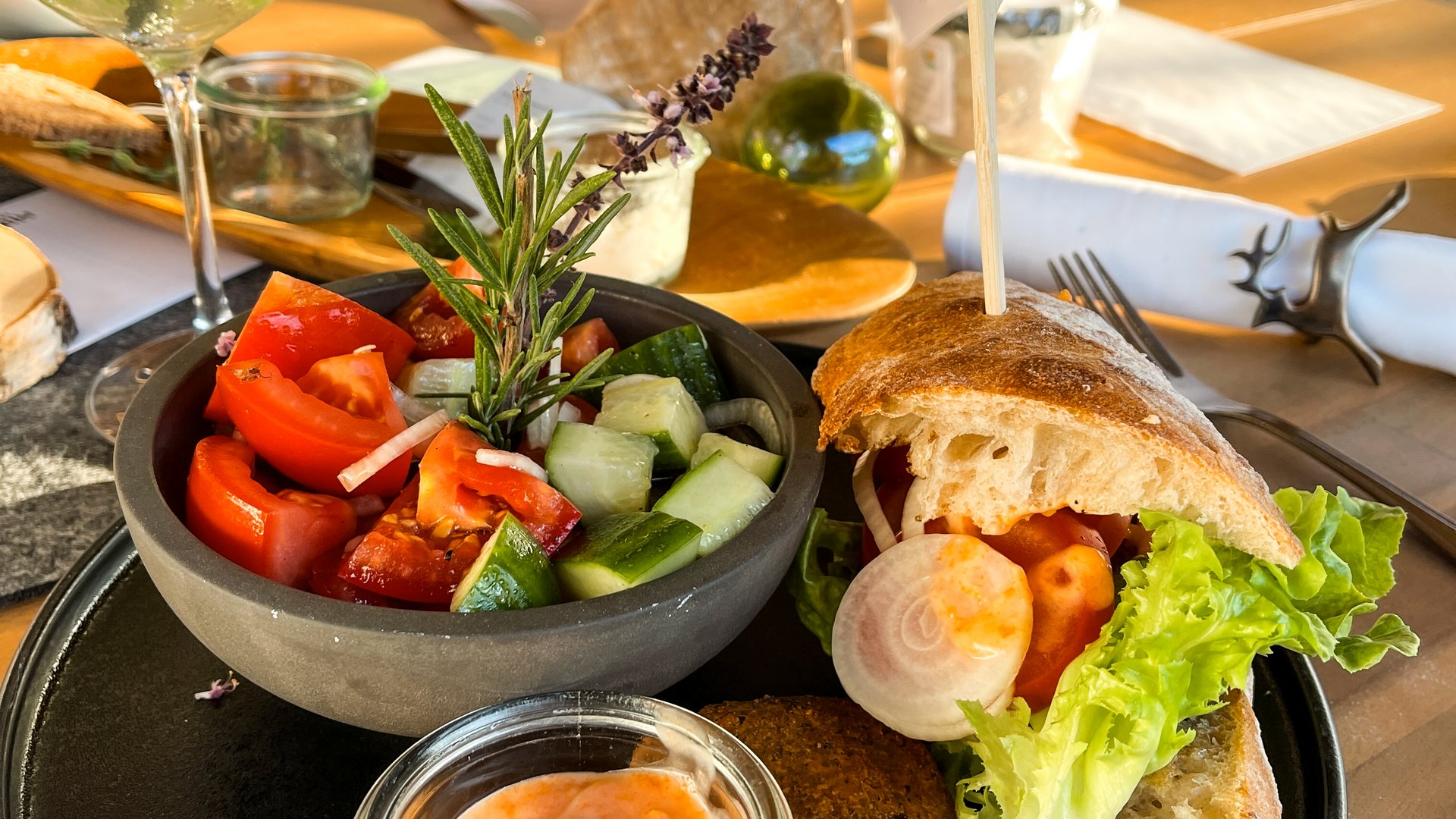 Beer garden in Parsberg: HirschenBlobb Plate with sandwich, salad, and dip in a restaurant with natural light