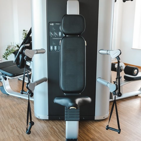 Fitnessraum Exercise machine with seat and handles in a modern gym