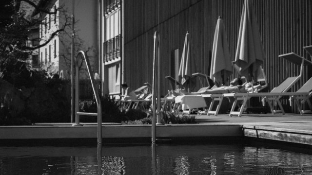 Familienhotel Oberpfalz: Hier gibt’s so viel zu erleben! Personen entspannen auf Liegestühlen neben einem Pool mit Sonnenschirmen