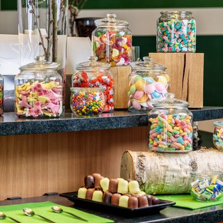 Tagungshotel mit Events gesucht? Verschiedene bunte Bonbons in Gläsern auf einer Theke arrangiert