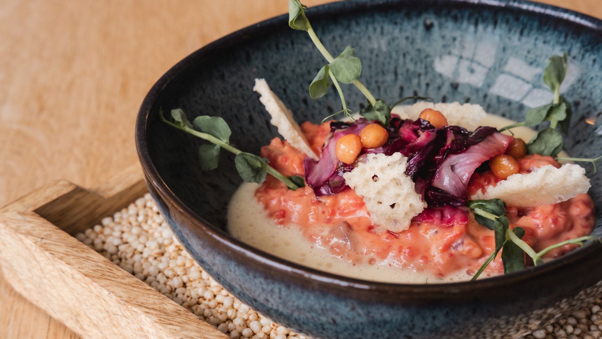 Hotel mit frühem Check-in Gourmetgericht mit Creme, Crostini und frischen Kräutern im blauen Teller
