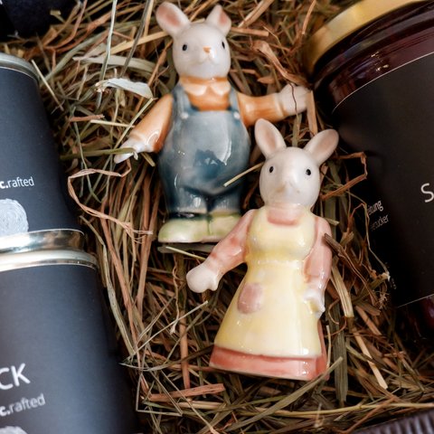 Nachhaltiges Hotel in Bayern mit Hirschenmanufaktur Zwei Hasenfiguren mit Dosen und Glas in Stroh