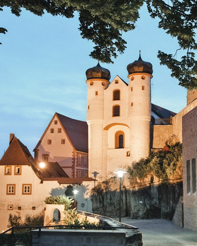 Wandern in der Oberpfalz: Aktiv in der Natur Historisches Gebäude mit Zwiebeltürmen bei Abenddämmerung in einer Stadt