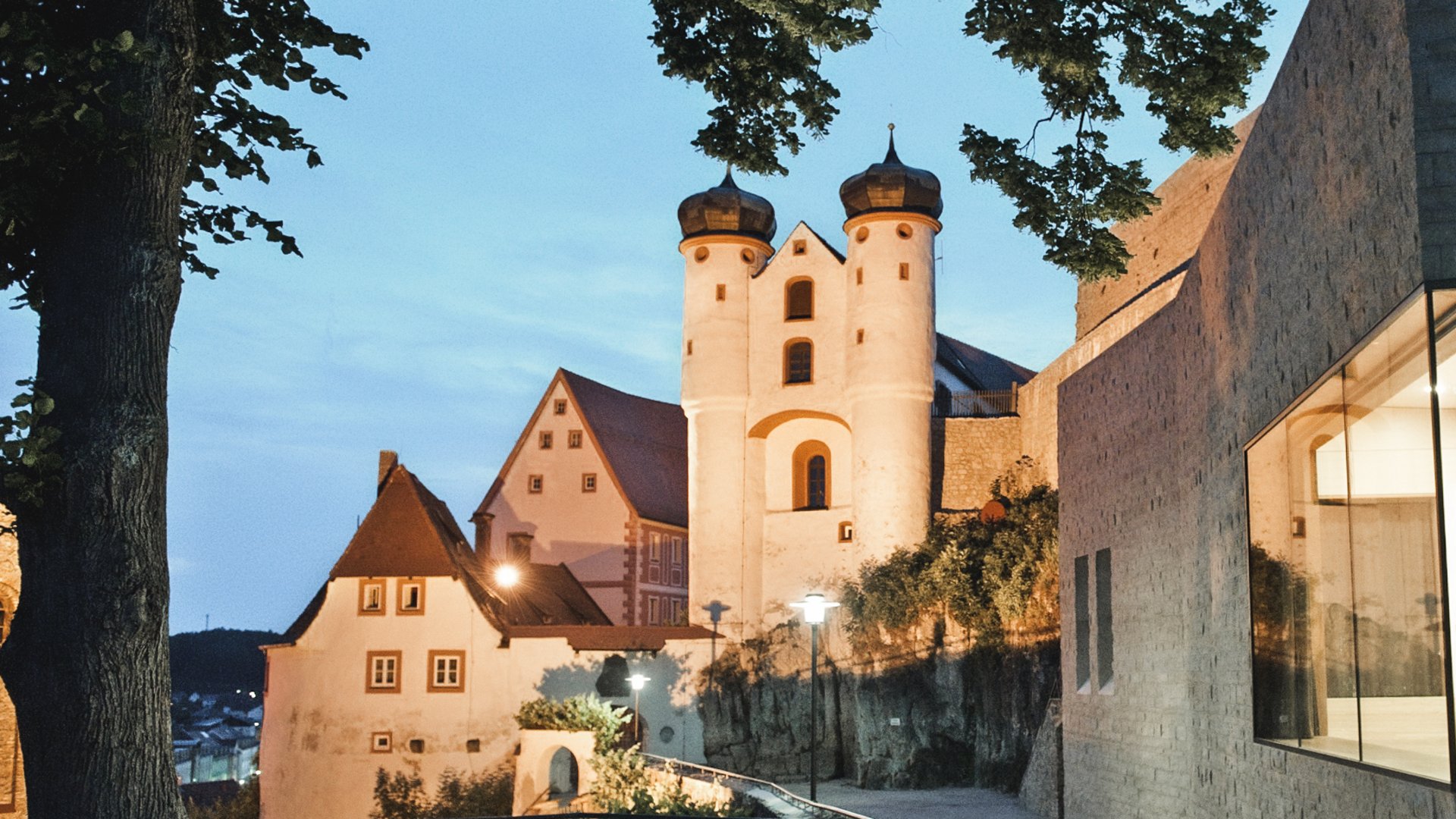 Family hotel Upper Palatinate: There’s so much to experience here! Historic building with onion domes at dusk in a town