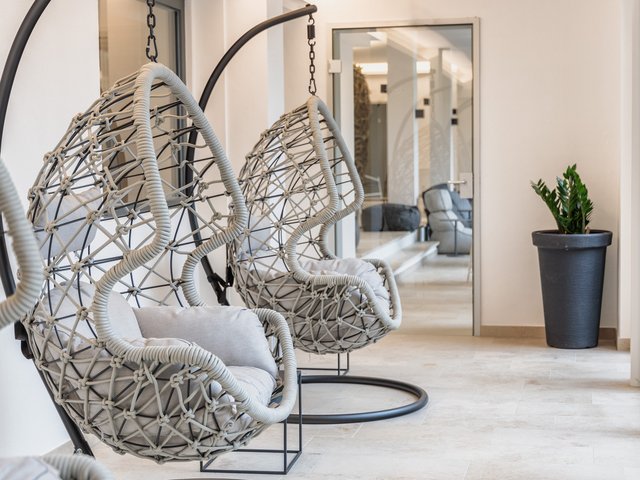 Wellnesshotel Parsberg – Romantik Hotel Hirschen Moderne Hängesessel mit Kissen in einem hellen, minimalistischen Raum