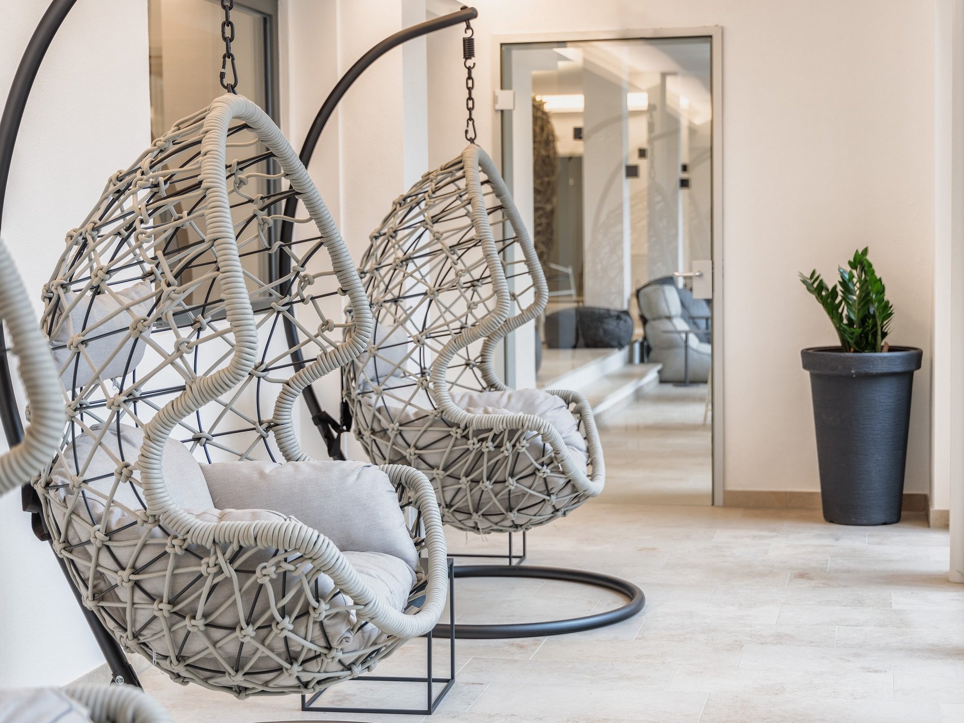 Wellness Modern hanging chairs with cushions in a bright minimalist room