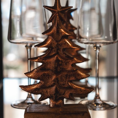 Eco-friendly hotel in Germany with Hirschenmanufaktur Bronze Christmas tree beside several empty wine glasses