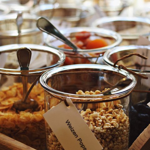 Romantik Hotel Hirschen: Frühstück Verschiedene Getreide und Trockenfrüchte in Glasbehältern mit Löffeln