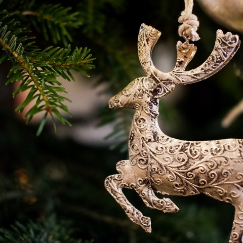 Gasthof Parsberg: Ein Gruß an den guten Geschmack Weihnachtlicher Hirsch-Anhänger mit Schnörkeln an grünem Tannenzweig